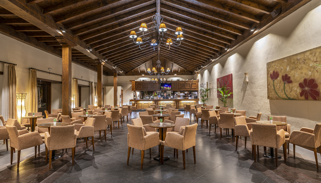 Large restaurant interior with wooden ceiling and beige chairs in Tenerife.
