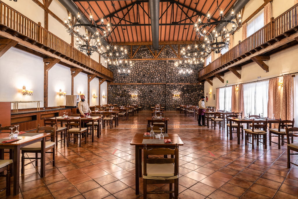 Spacious restaurant with wooden tables and chandeliers in Tenerife.