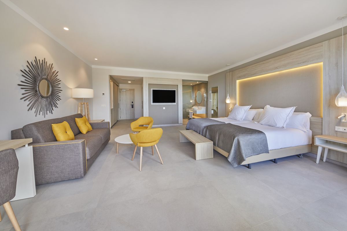 Hotel room with double bed, sofa, and TV in Tenerife.