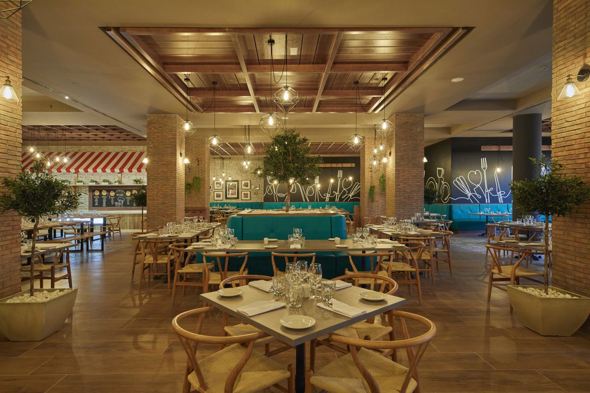 Restaurant interior with wooden tables and chairs, decorated with plants, located in Tenerife.