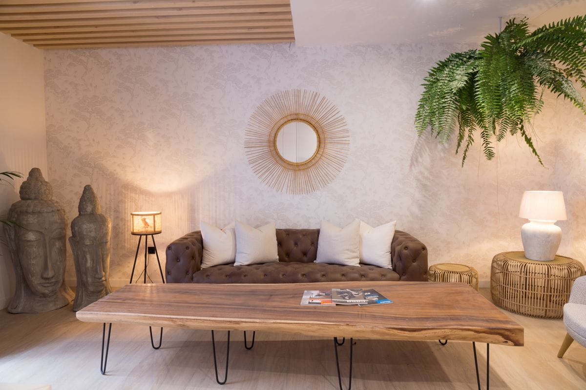 Brown sofa and wooden coffee table with a mirror and plants in a Tenerife room.