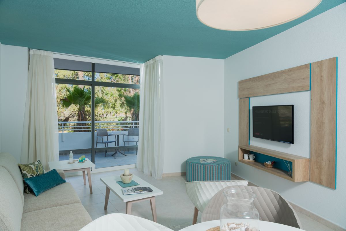 Living room with a view of a balcony and palm trees in Tenerife.