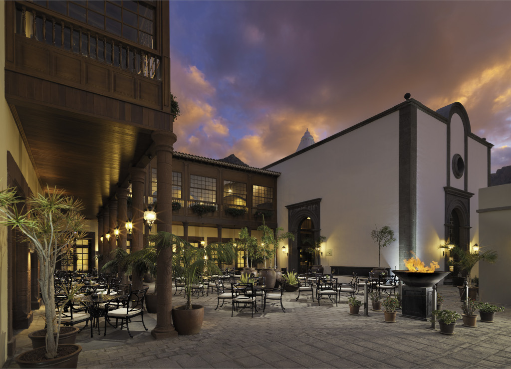 Outdoor dining area with plants and fire pit at sunset in Tenerife.
