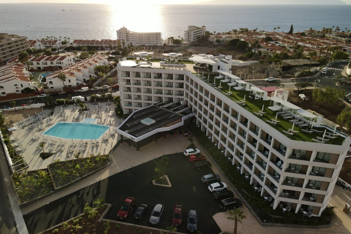 Hotel with pool and ocean view in Tenerife at sunset.