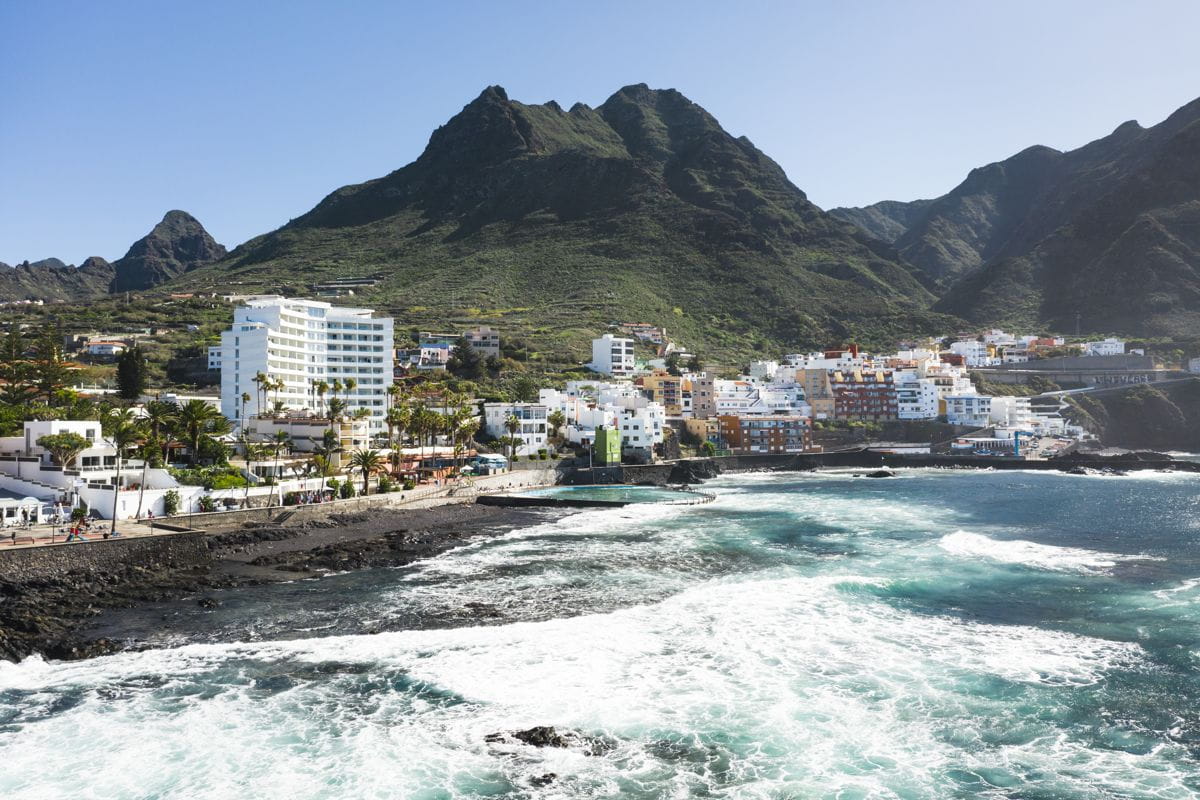 Coastal village with colorful buildings and mountains in Tenerife.