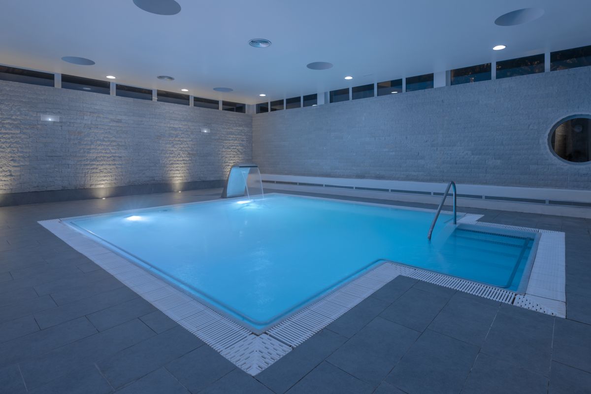 Indoor pool with blue lighting and water features in Tenerife.