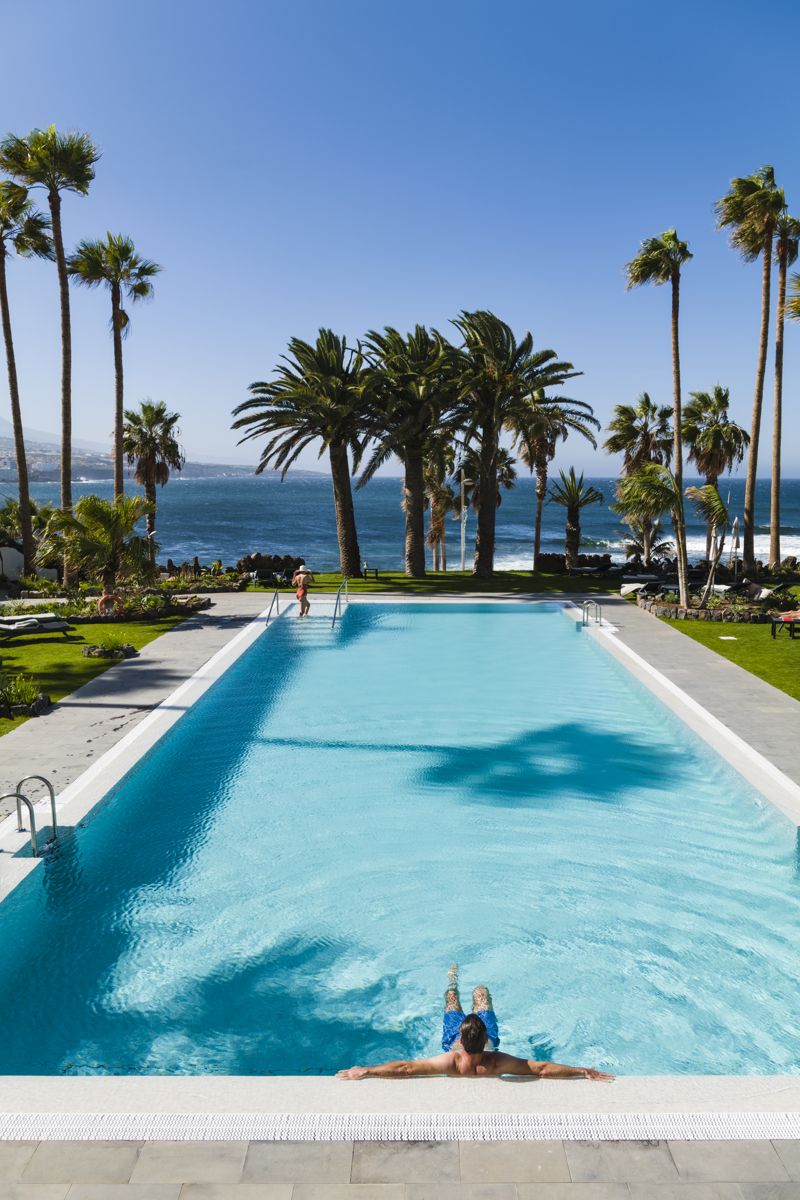 Pool with palm trees and ocean view in Tenerife.