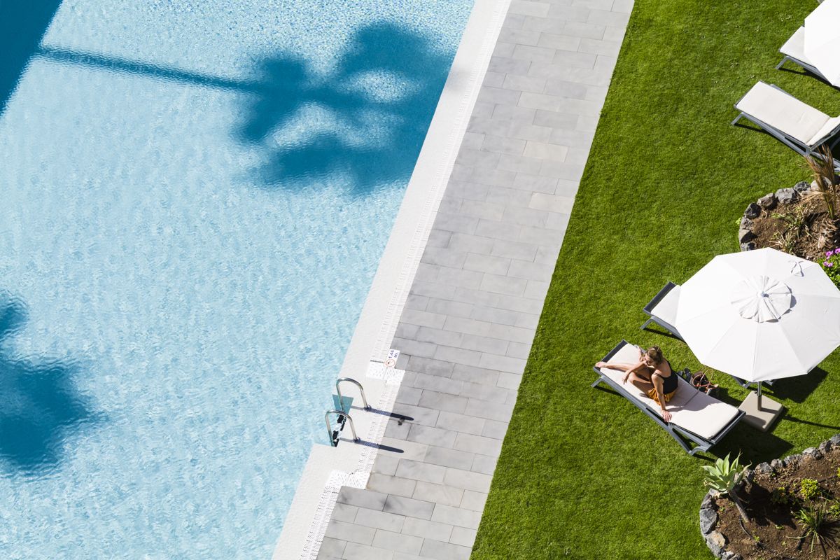 Lounger and umbrella by a pool on a sunny day in Tenerife.