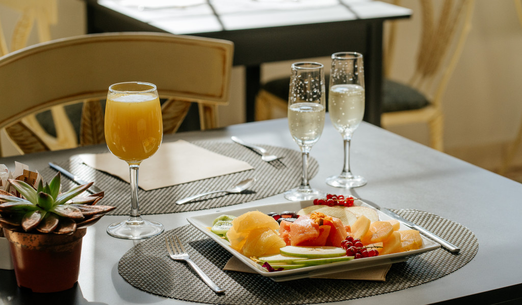 Fresh juice, champagne, and fruit plate on a table in a Tenerife restaurant.