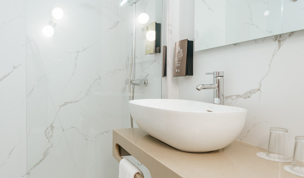 Modern bathroom sink with two glasses on a marble countertop in Tenerife.