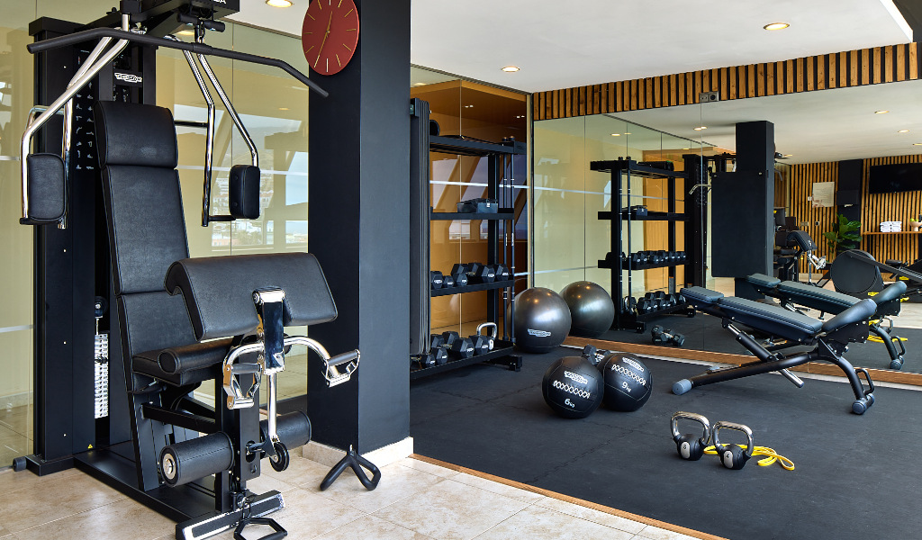 Gym area with weights, exercise machines, and yoga balls at Tenerife fitness center.