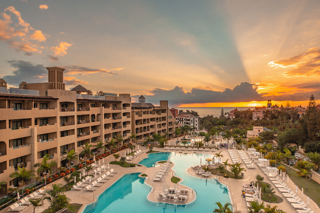 Pool and resort buildings at sunset in Tenerife.