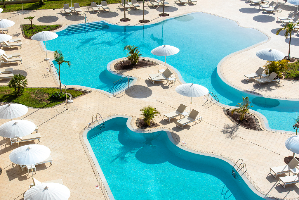 Outdoor pool area with sun loungers and umbrellas in Tenerife resort.