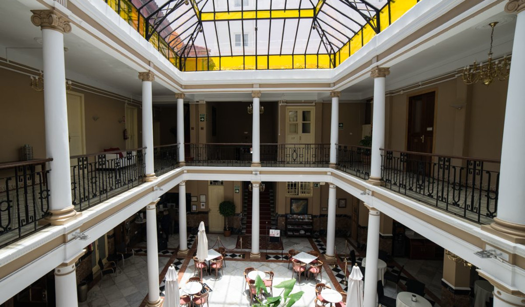 Atrium with tables, chairs, and a glass ceiling in a Tenerife building.