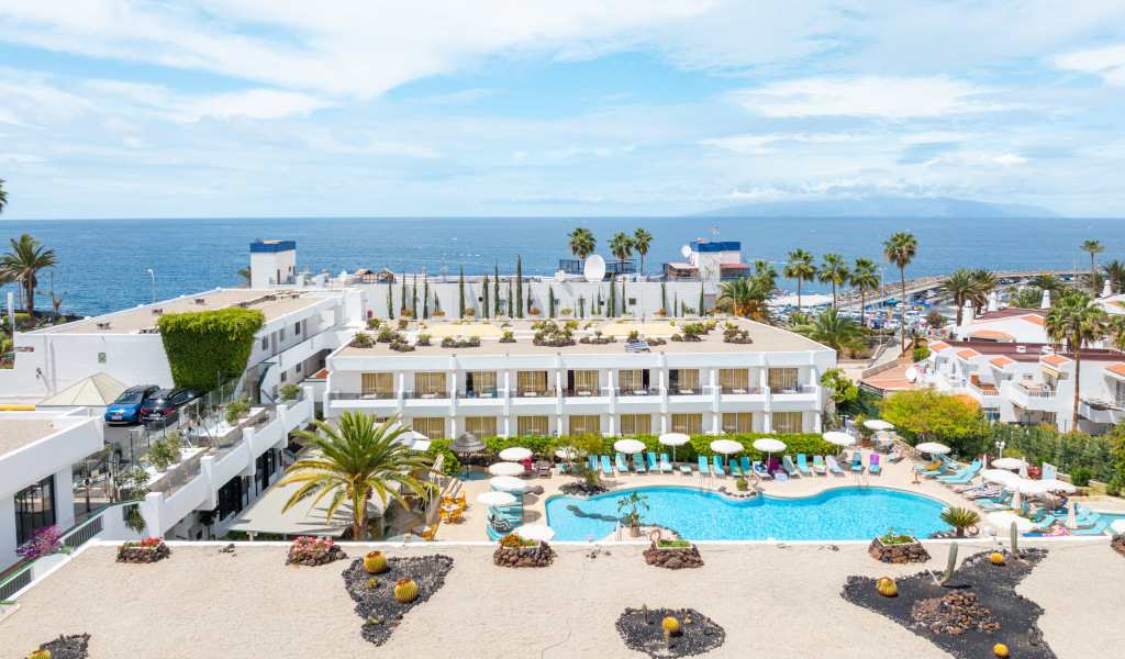 Hotel by the sea with pool and loungers in Costa Adeje, Tenerife.