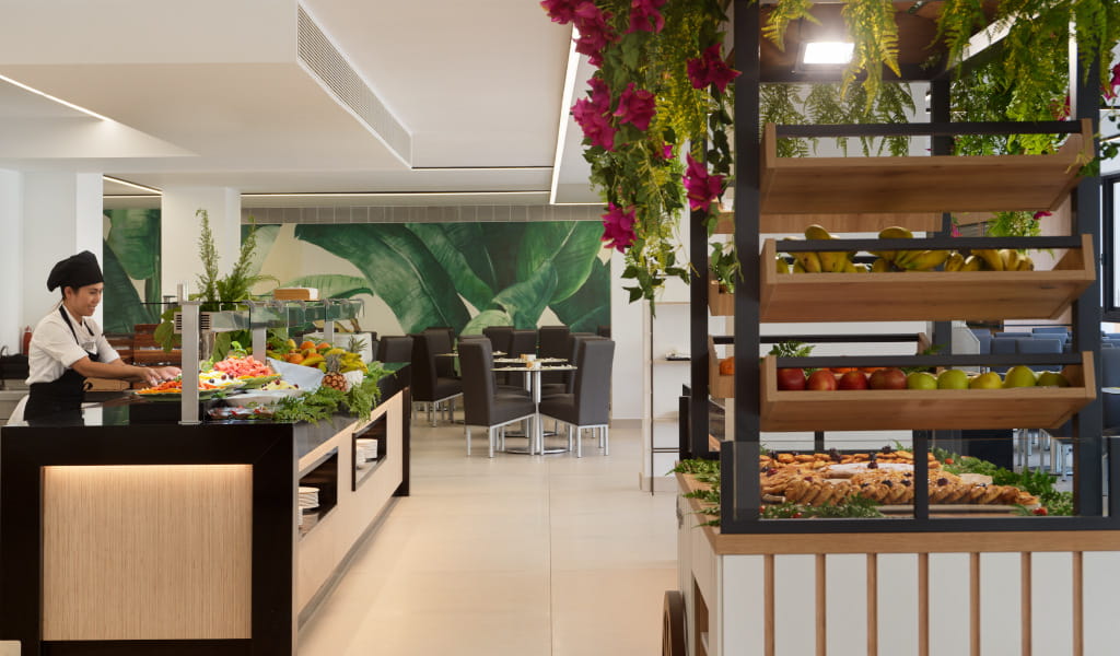 Chef preparing buffet with fresh fruits and bread in Tenerife restaurant.