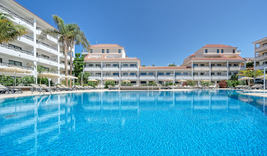 Outdoor pool with sun loungers at a hotel in Tenerife.