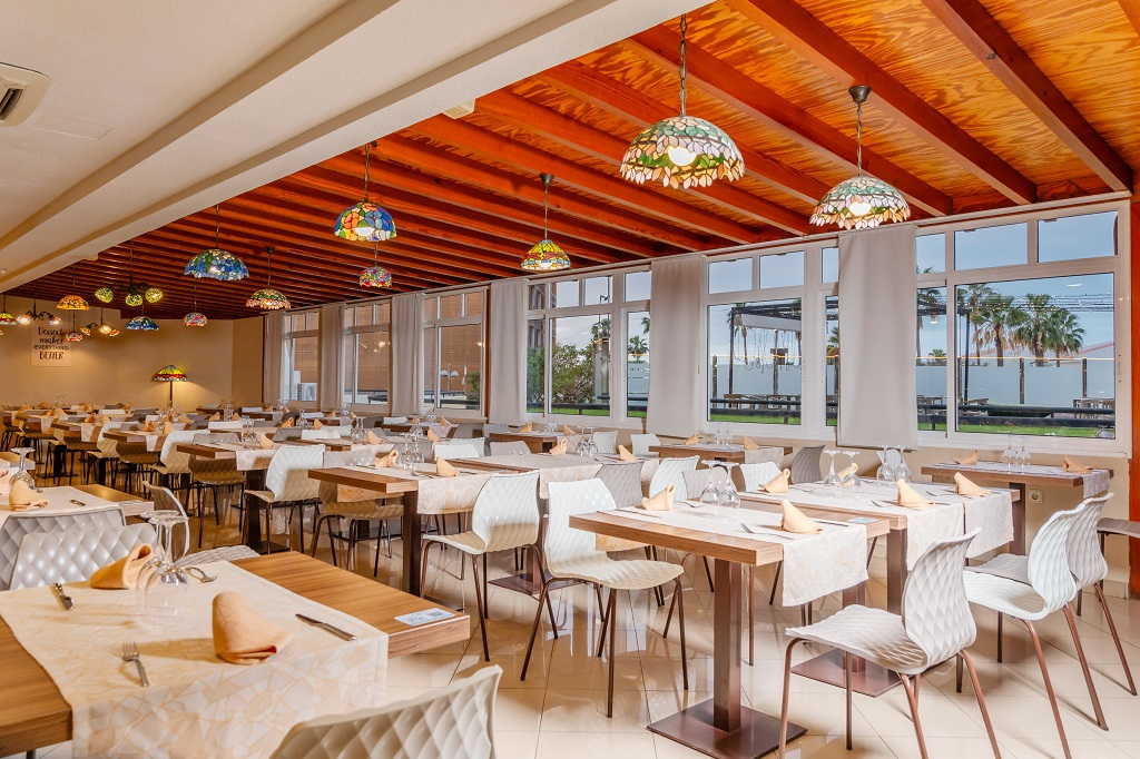 Restaurant dining area with tables, chairs, and colorful lamps in Tenerife.