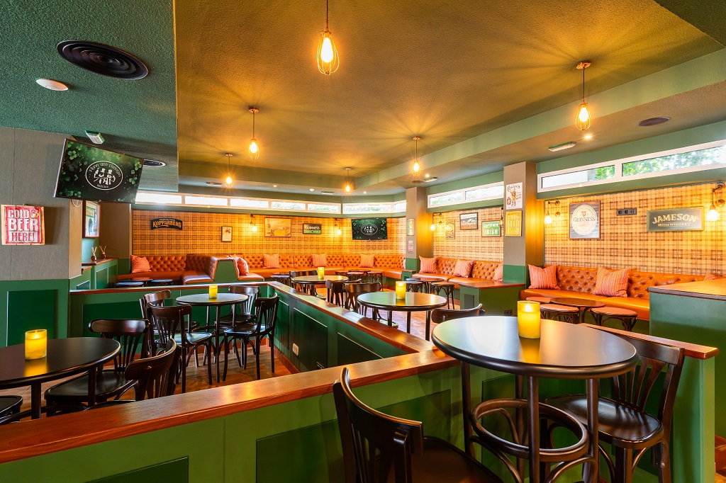Spacious pub interior with round tables, chairs, and cozy seating in Tenerife.