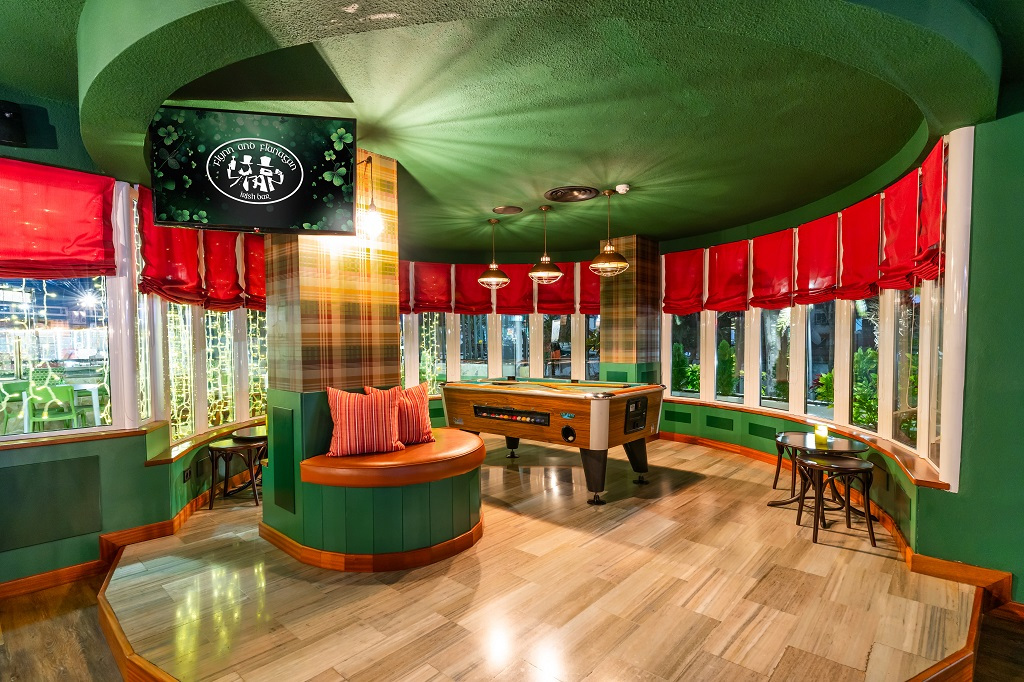 Pool table and seating area with red curtains in Tenerife lounge.