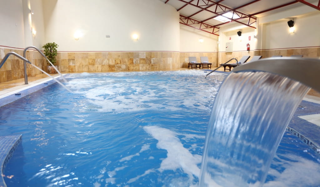 Indoor pool with cascade feature and loungers in Tenerife.