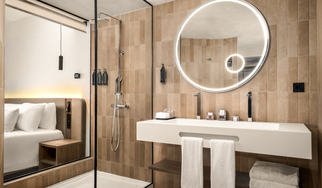 Modern bathroom with round mirror and shower. Room view from hotel in Tenerife.