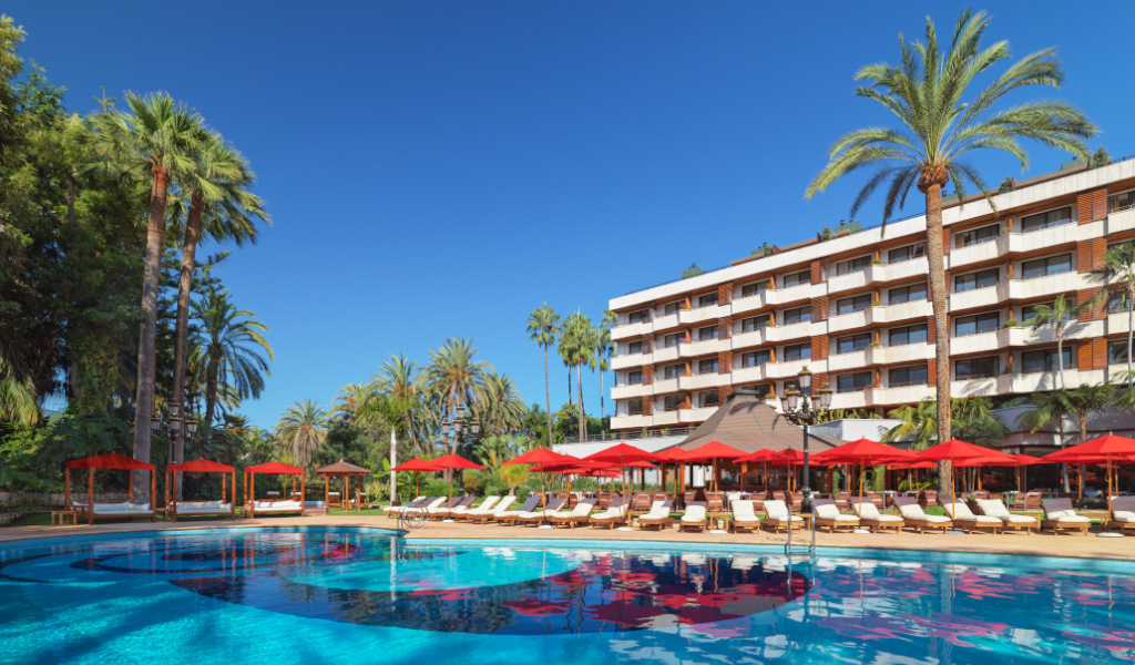 Outdoor pool area with red umbrellas at a hotel in Tenerife.