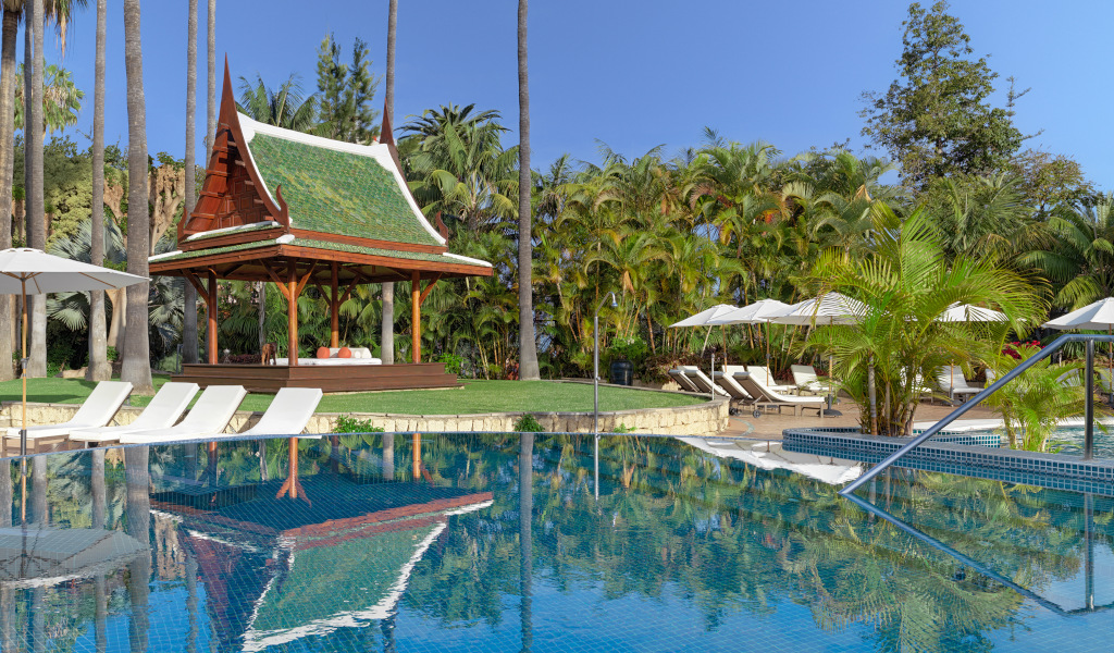 Thai pavilion by the pool with palm trees in a Tenerife resort.