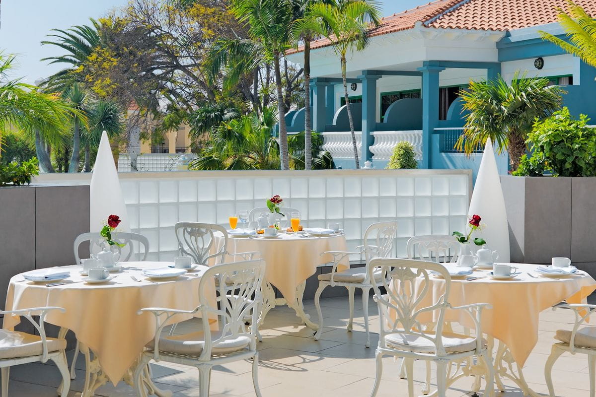 Outdoor terrace with tables set for breakfast in hotel, Tenerife.