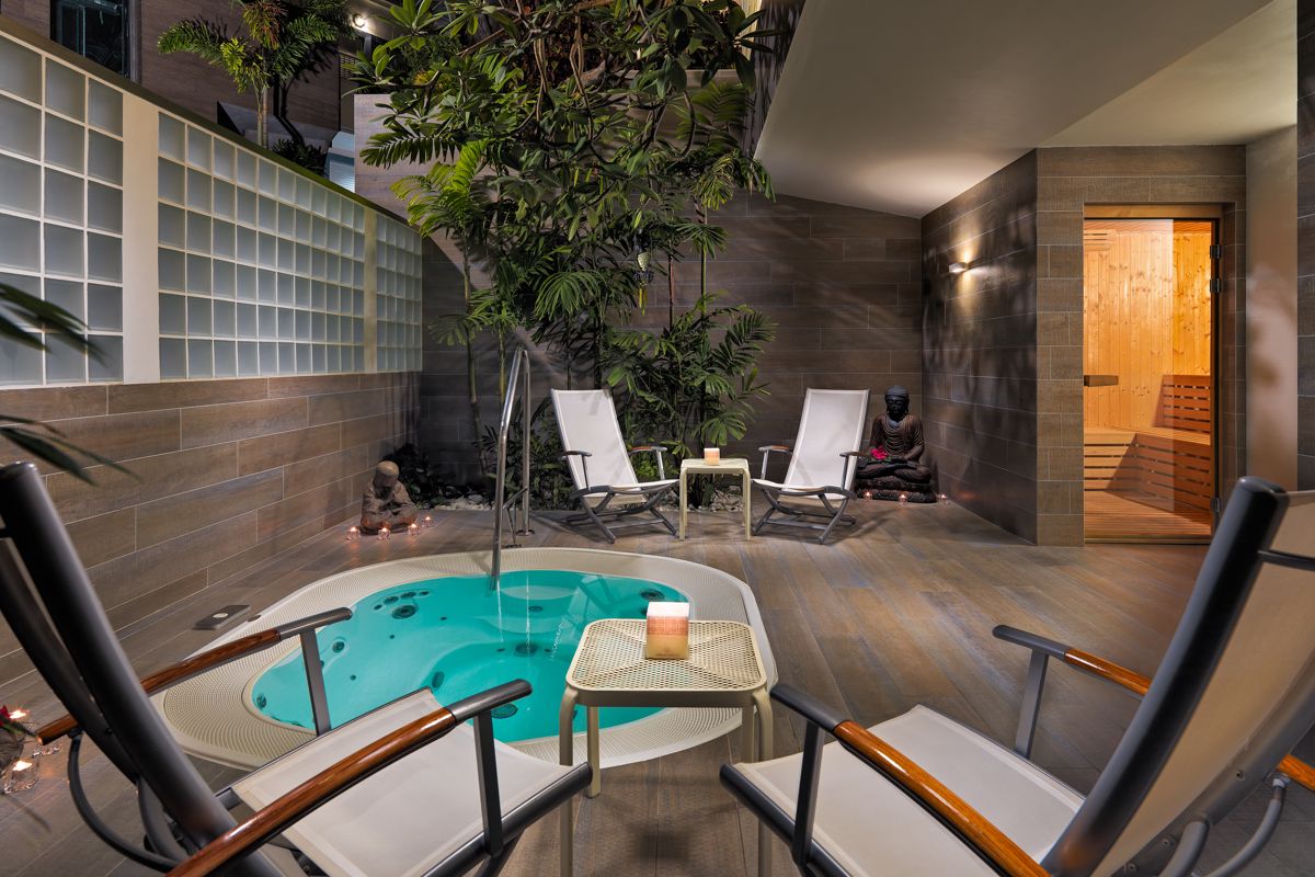 Jacuzzi and sauna area with chairs and plants in a Tenerife spa.