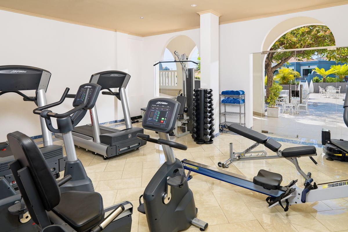 Gym with exercise machines and weights at a hotel in Tenerife.