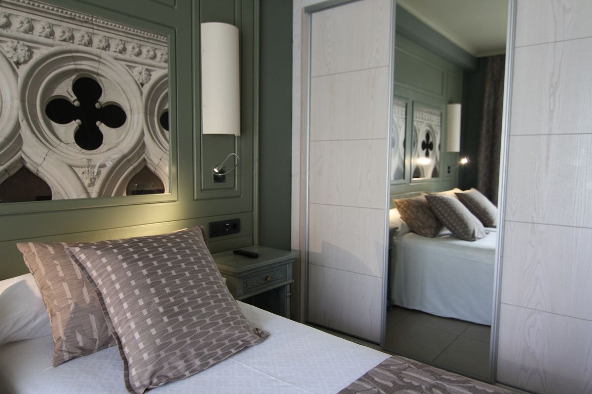 Hotel room in Tenerife with decorative mirror and geometric pillows.