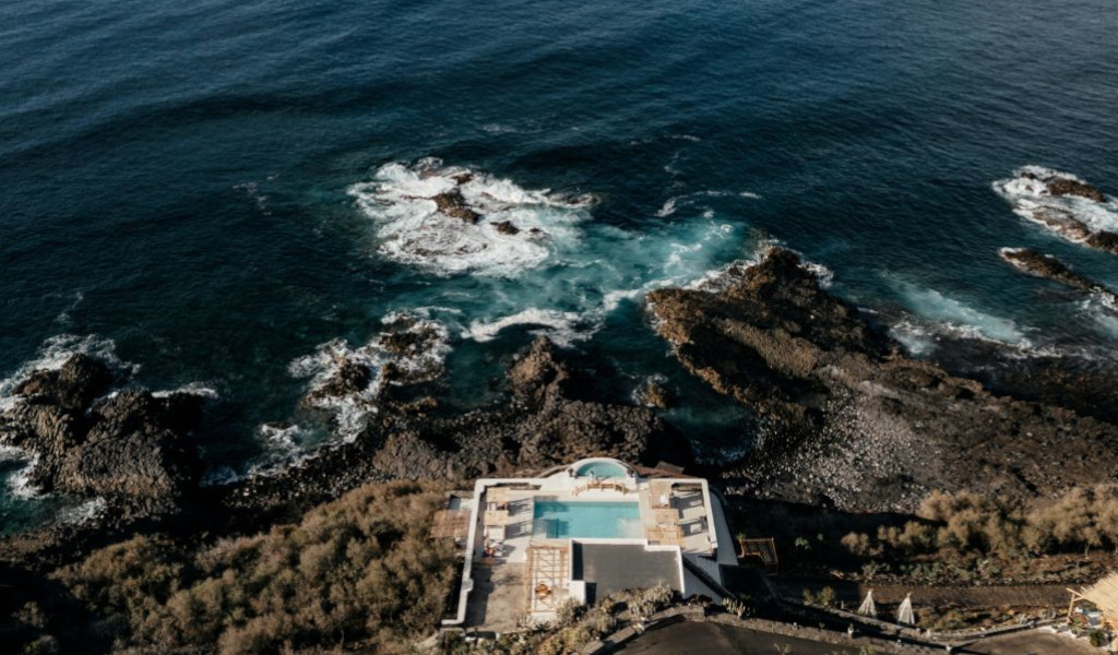 Infinity pool overlooking the ocean and rocky shore in Tenerife.