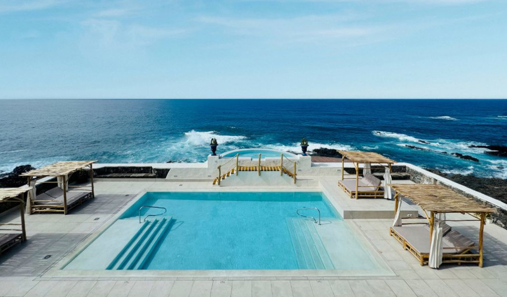Oceanfront pool with cabanas overlooking the sea at a location in Tenerife.