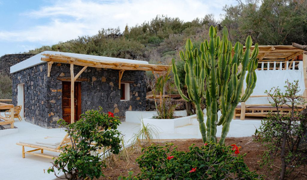 Stone house with a wooden pergola and cactus in Tenerife garden.