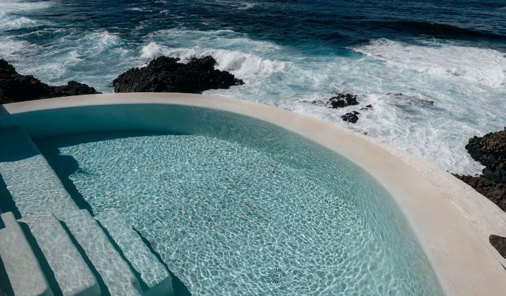 Infinity pool overlooking ocean waves in Tenerife.