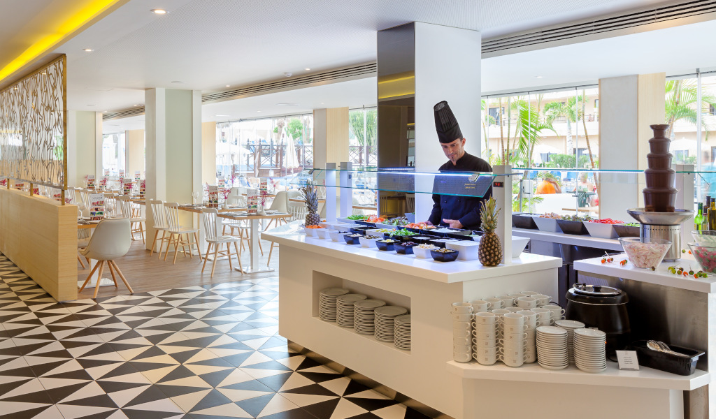 Buffet de desayuno en un restaurante de Tenerife con chef preparando platos.