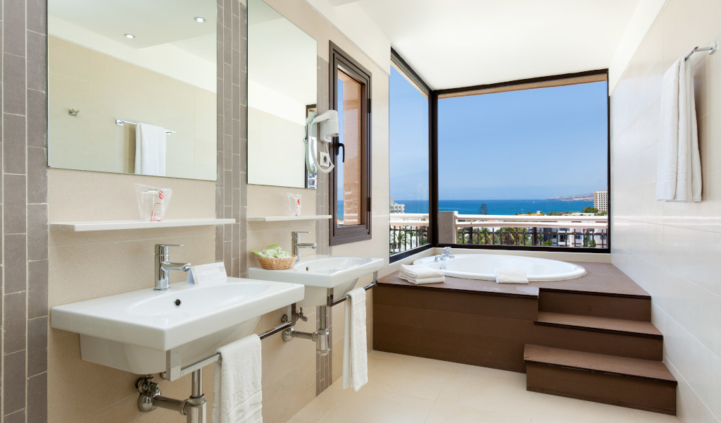 Bathroom with two sinks and a jacuzzi overlooking the ocean in Tenerife.