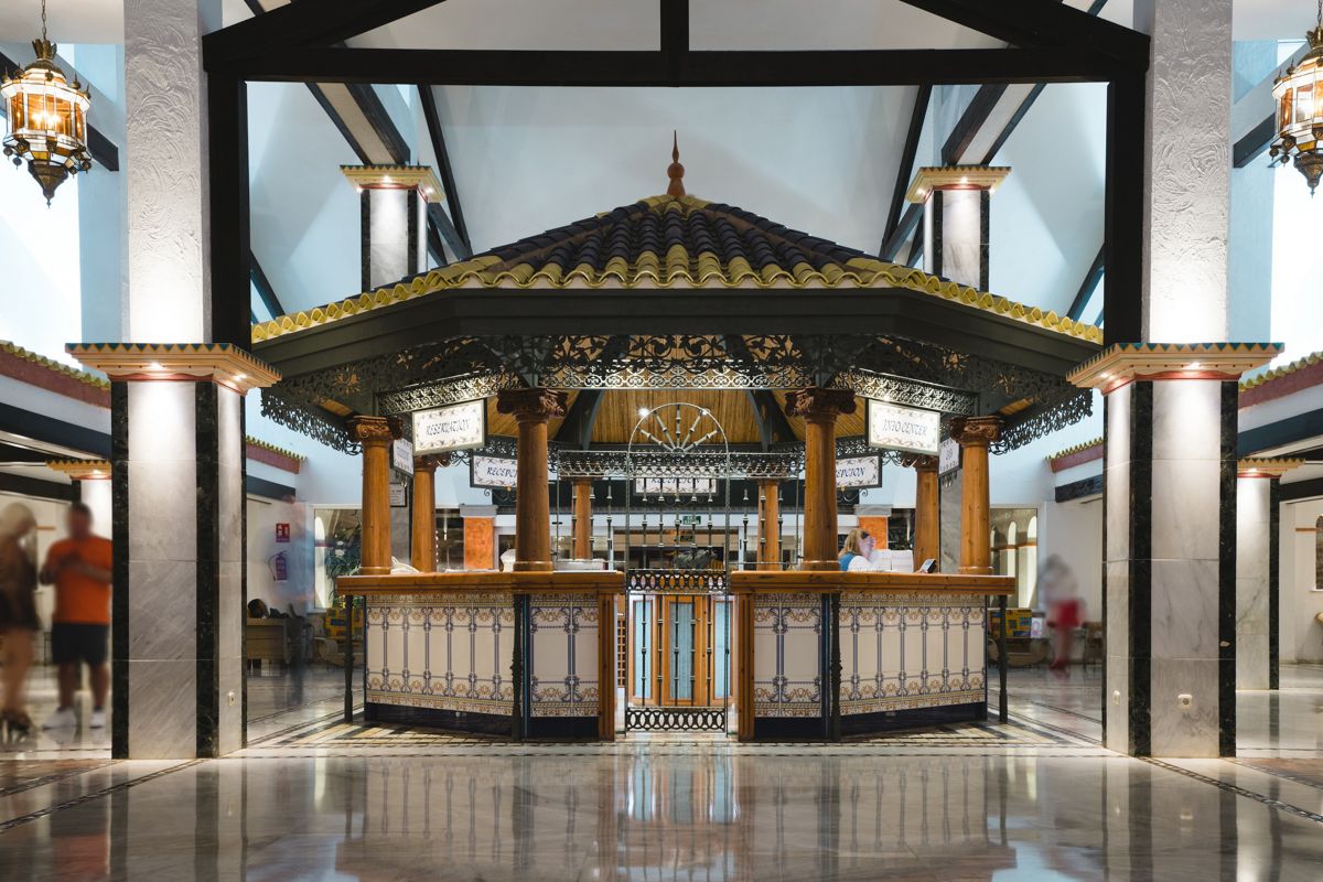 Hotel lobby with decorative wooden desk and Reception” signs in Tenerife.