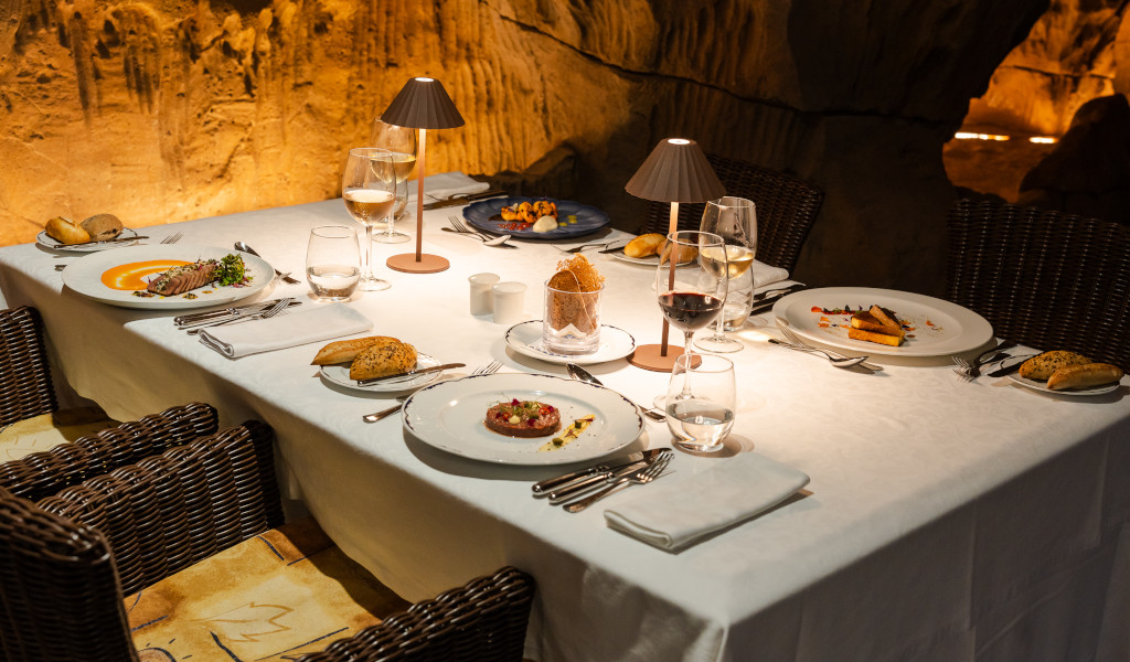 Dining table set with gourmet dishes in a cave-like restaurant in Tenerife.