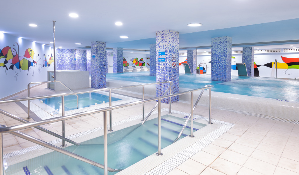 Indoor pool area with colorful wall art and multiple pools, Tenerife.