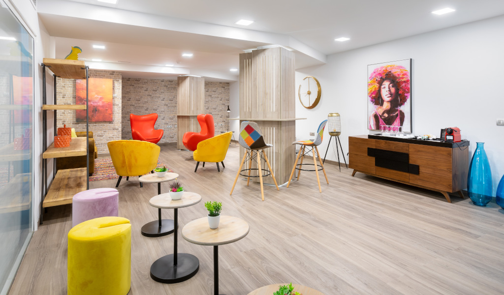 Modern lounge with colorful chairs, artworks, and furnishings in a Tenerife location.