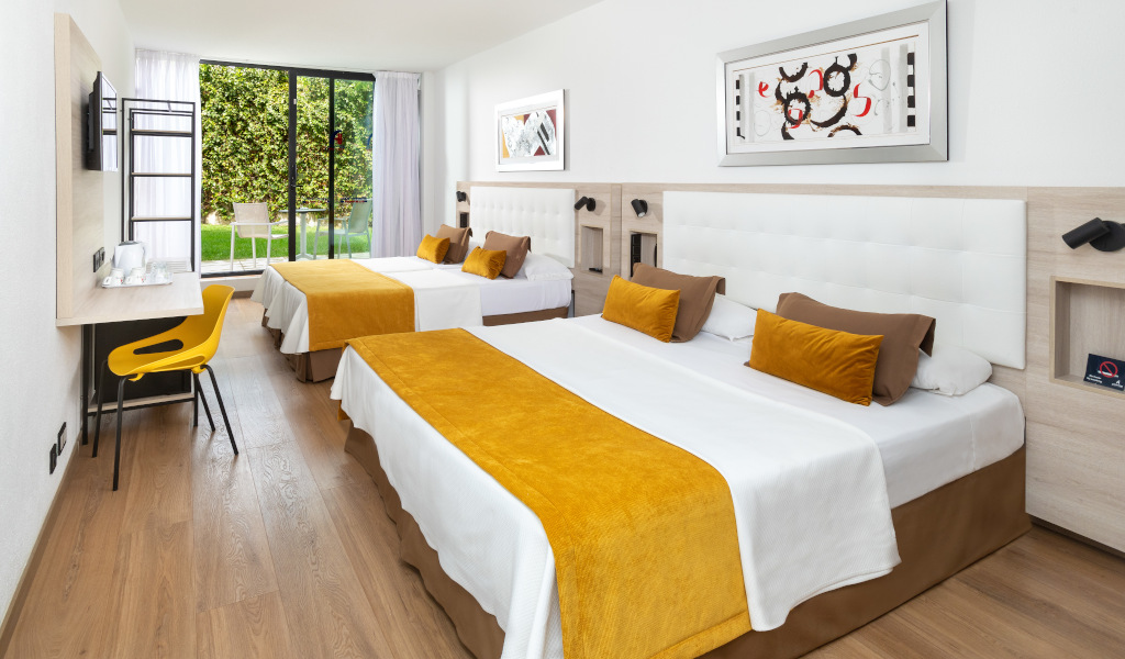 Hotel room with two large beds and a view of the garden in Tenerife.