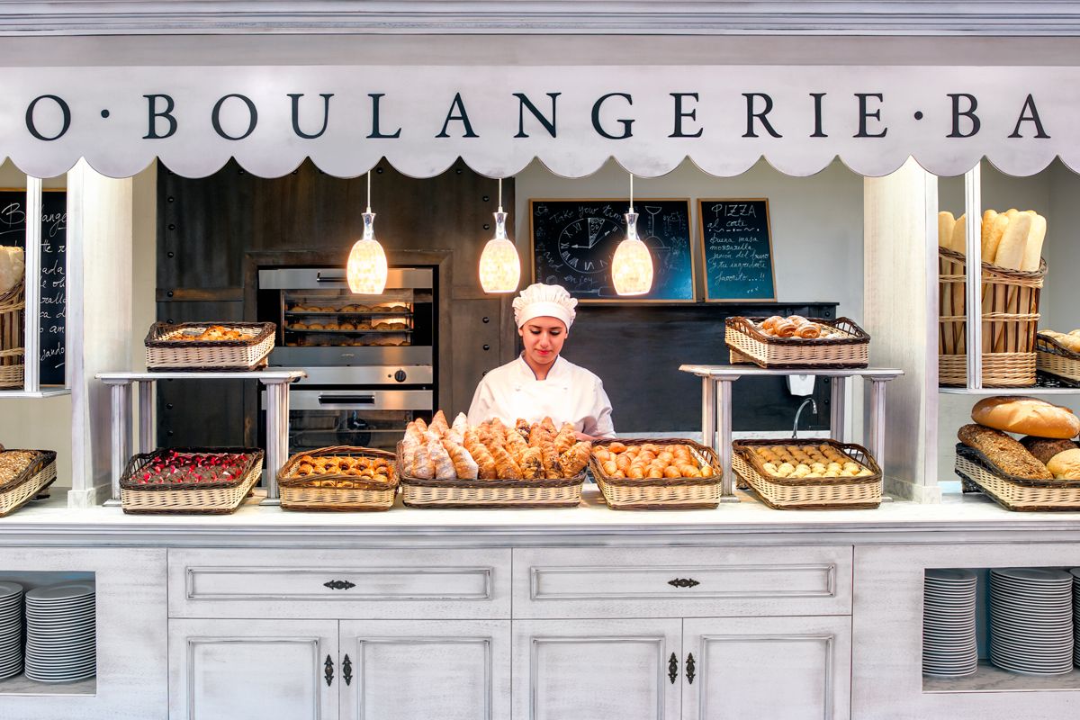 Baker arranging bread and pastries in baskets at a boulangerie in Tenerife.