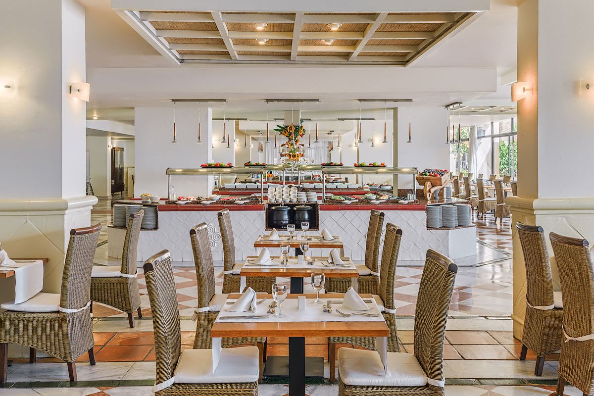 Restaurant in Tenerife with neatly set tables and buffet in the background.