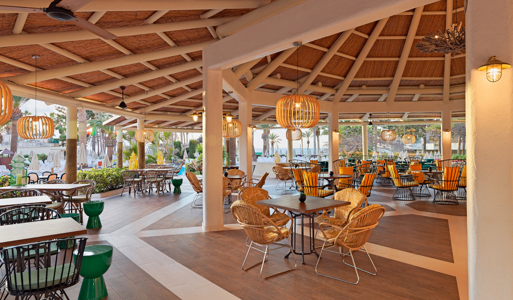 Outdoor seating area with wicker chairs and tables at a restaurant in Tenerife.