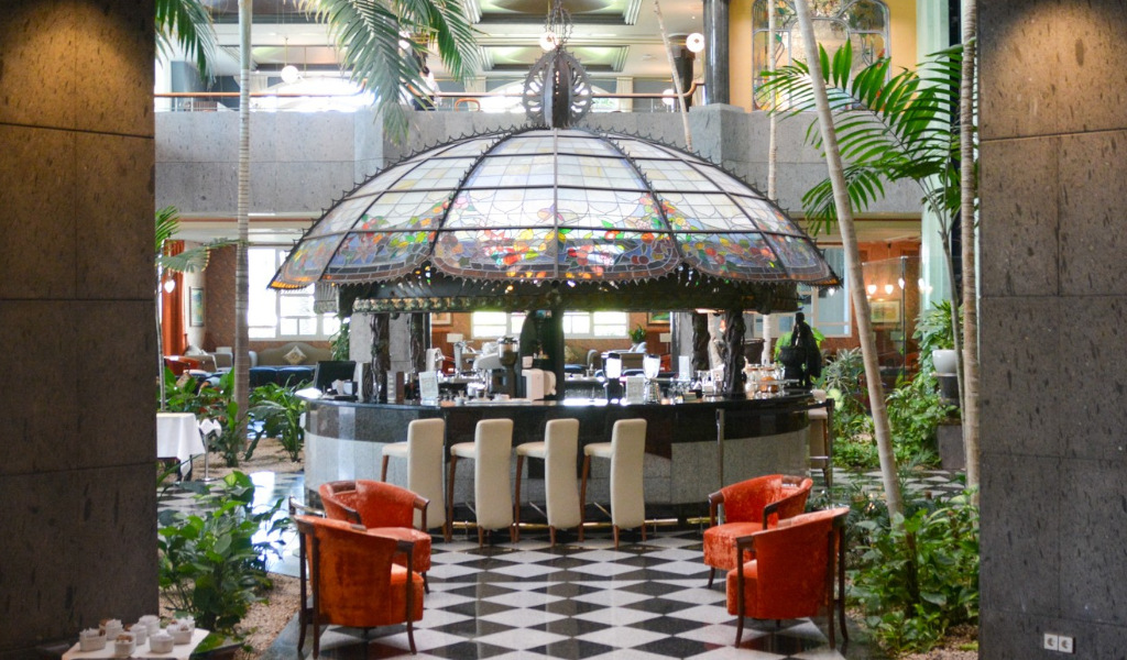 Central bar with stained glass dome and chairs in a hotel lobby in Tenerife.