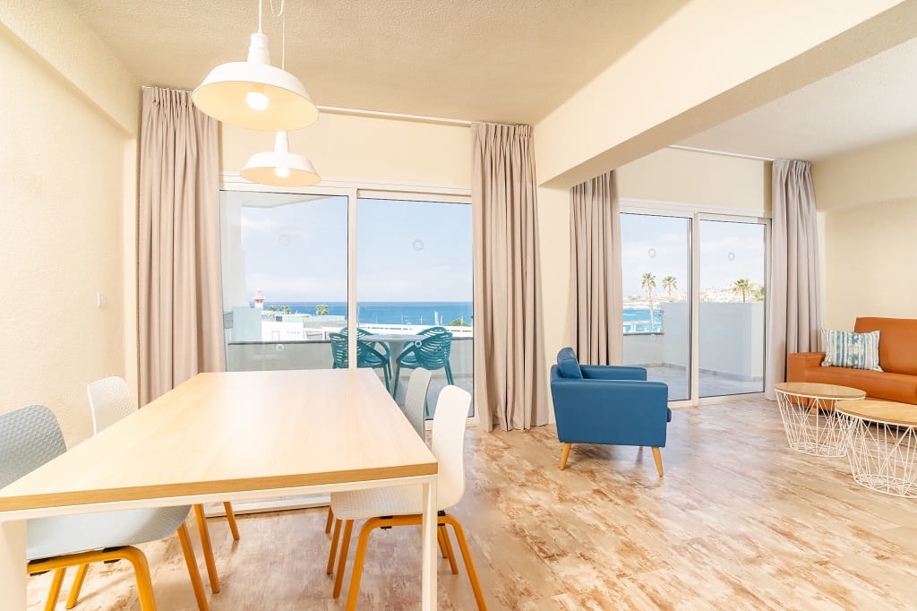 Modern living room with ocean view and balcony in Tenerife apartment.