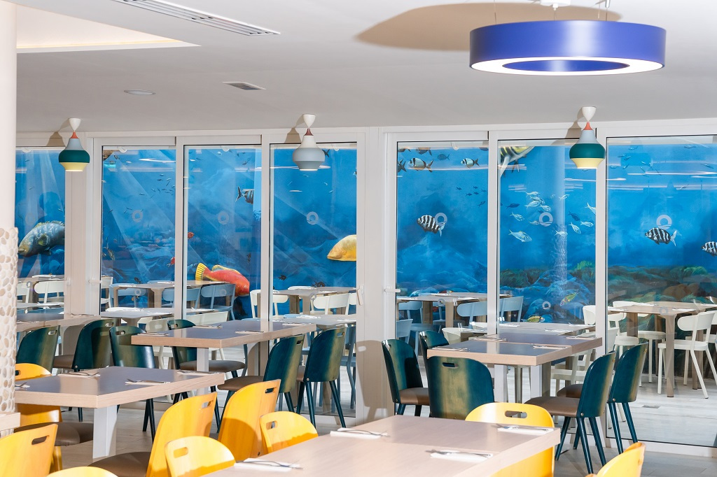 Dining room with marine-themed wall and colorful chairs in Tenerife.