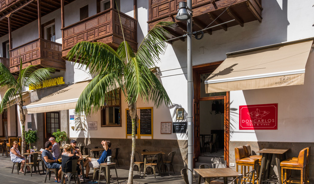 Outdoor seating area of Don Carlos restaurant in Tenerife with people dining.